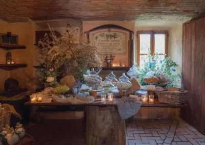 Tavolo all'interno di una stanza del Mulino dell'Olio con sopra confetti di ogni tipo e colore con fiori secchi e freschi