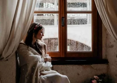 Modella che guarda fuori dalla finestra in una giornata autunnale al Mulino dell'Olio a Clivio Varese
